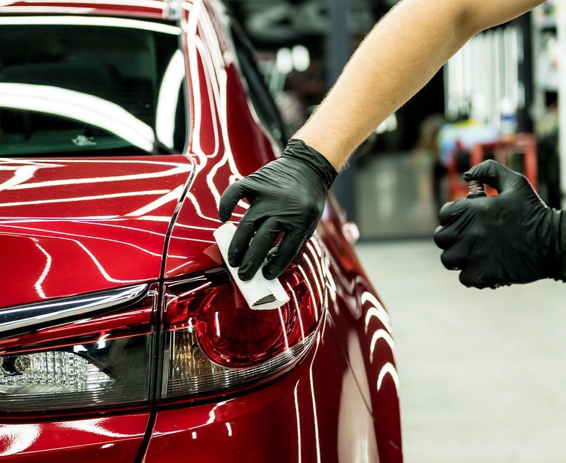 Ceramic coating being applied to a red car