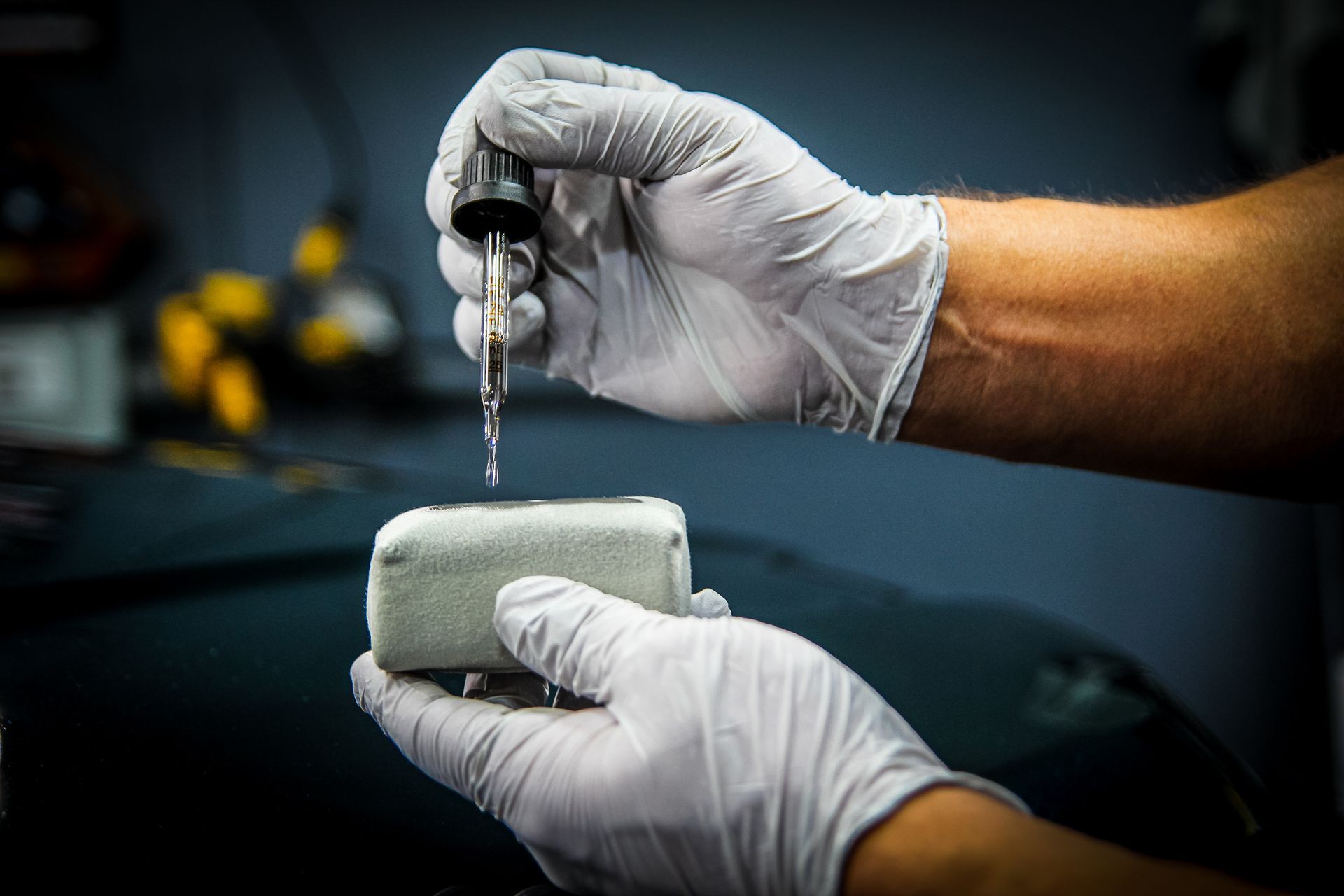 Ceramic coating being applied to a suede applicator pad using a precision measured dropper.