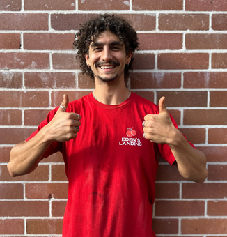 Friendly Eden’s Landing team member at organic fruit and vegetable store in Mullumbimby, NSW, supporting local produce and community.