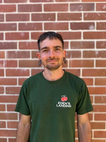 Friendly Eden’s Landing team member at organic fruit and vegetable store in Mullumbimby, NSW, supporting local produce and community.