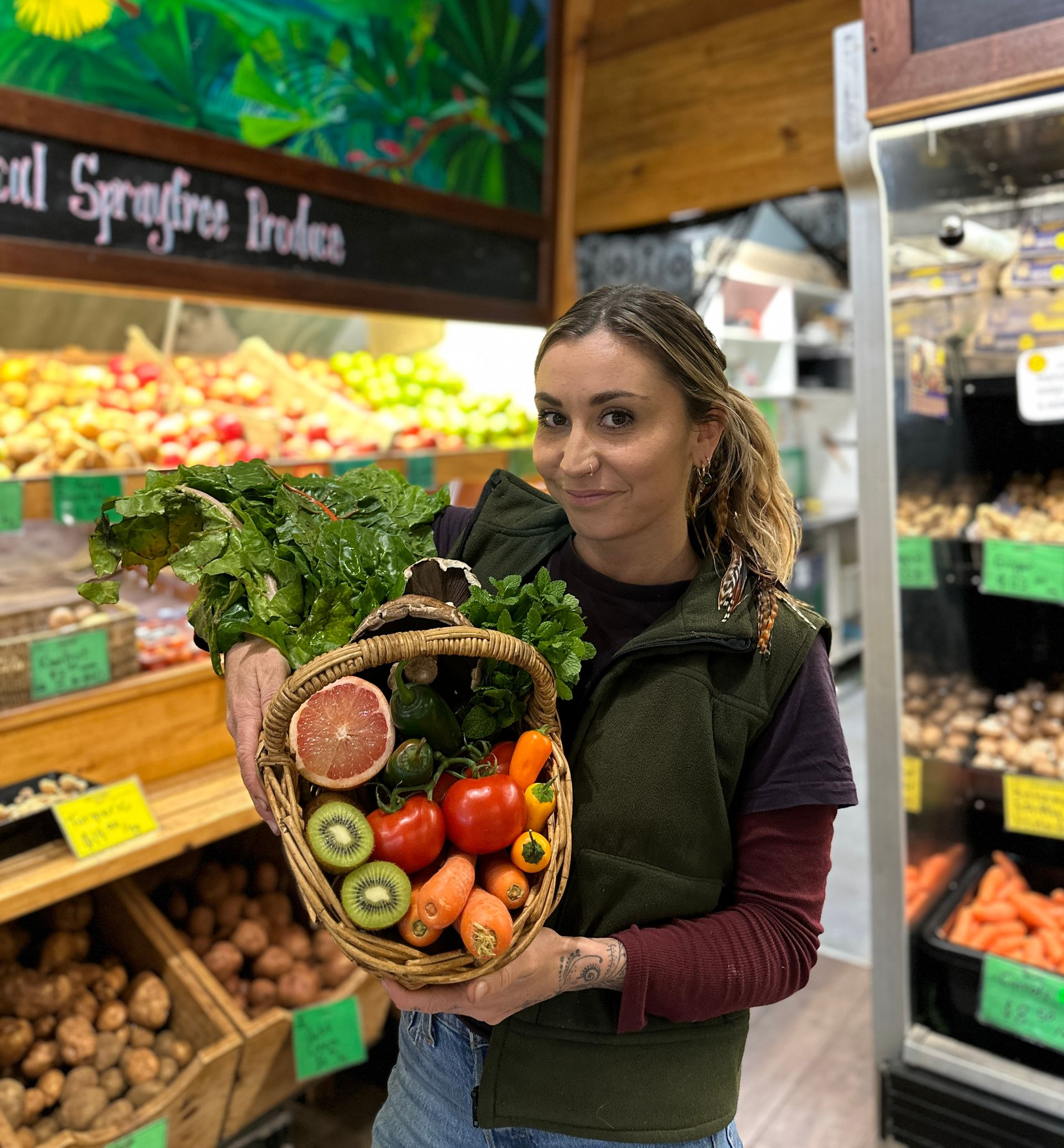 Jess holding a basket of fresh local produce at Eden’s Landing in Mullumbimby
