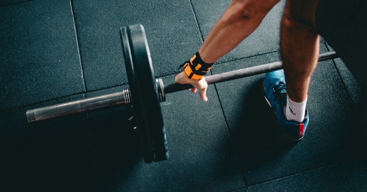 A person is lifting a barbell in a gym.