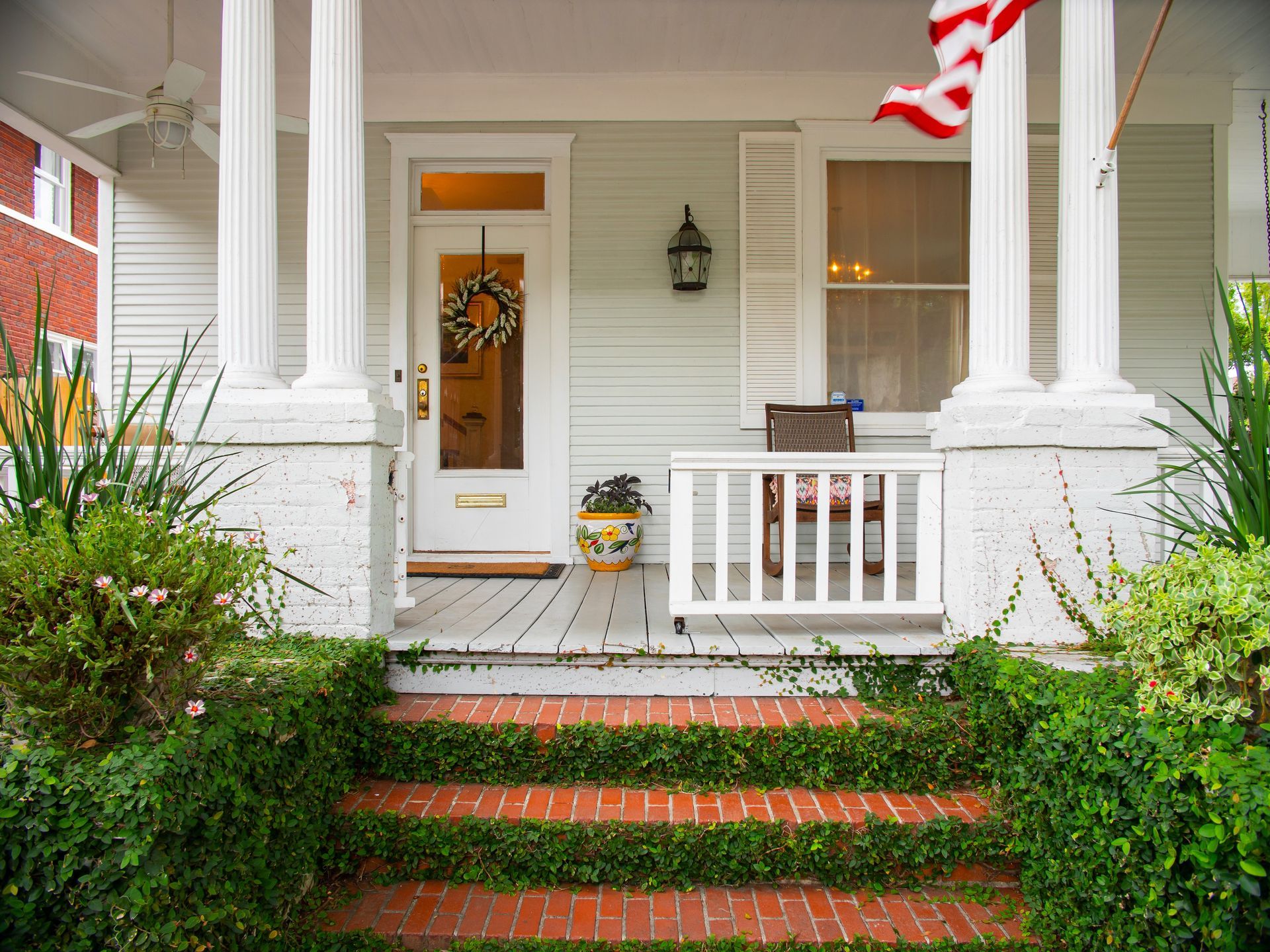 The front porch of a house with a flag on it