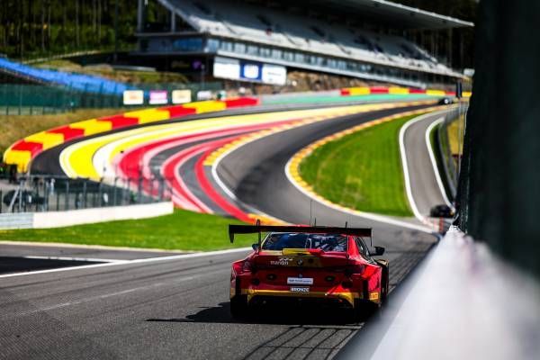 Formula 1 race cars speeding on track at the Abu Dhabi Grand Prix. The sun sets over the crowd-filled stands.