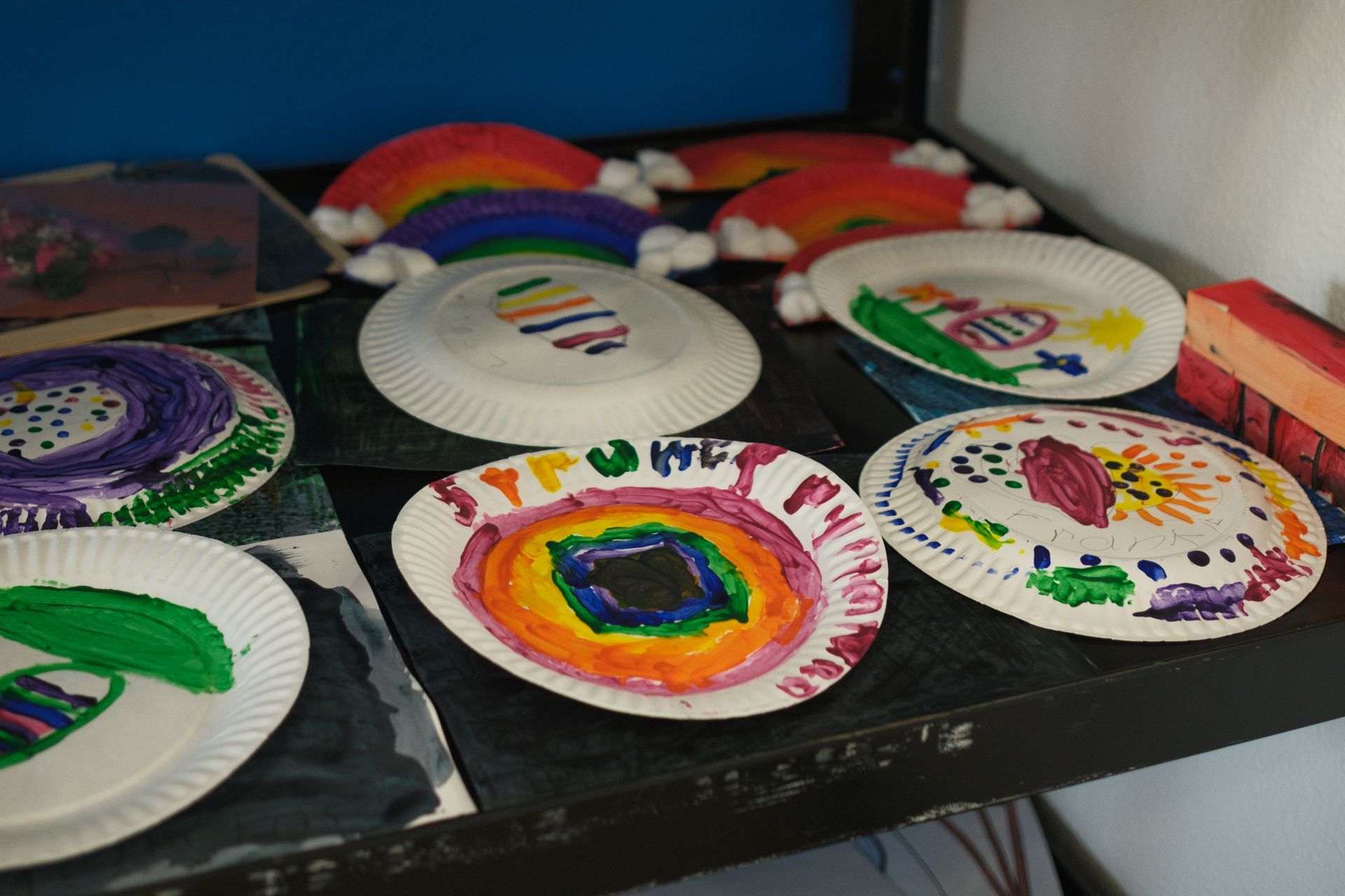 Group of people high-fiving outdoors in a grassy field. They are smiling, dressed in athletic wear.