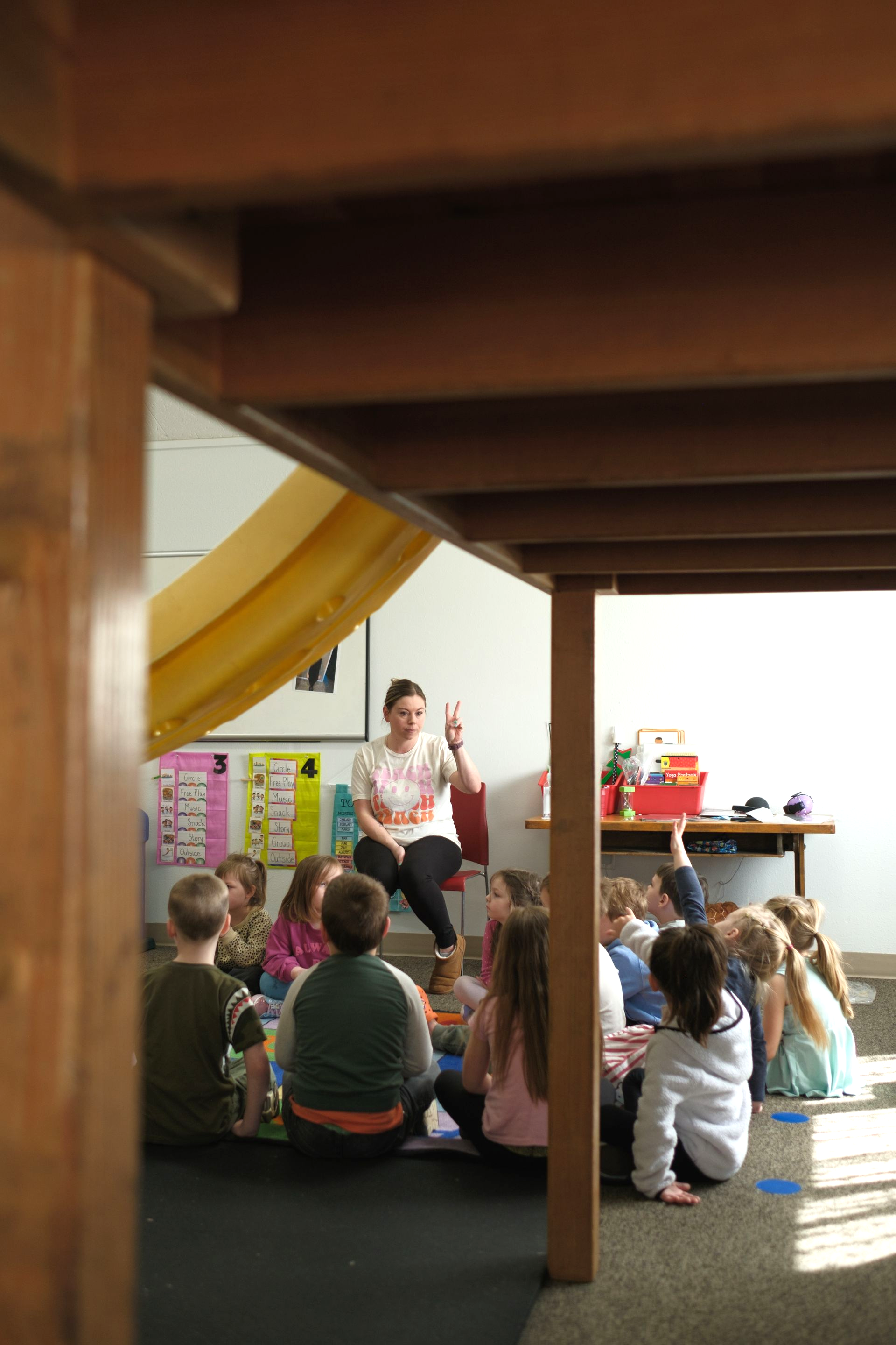 Group of people high-fiving outdoors in a grassy field. They are smiling, dressed in athletic wear.