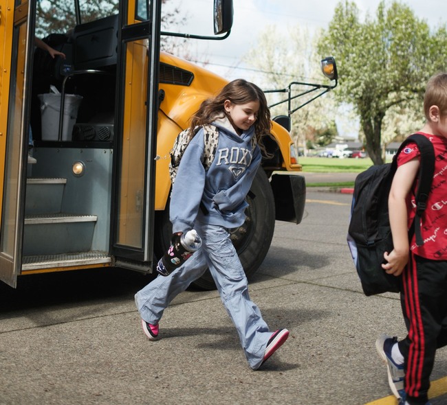 Man and baby lying on green carpet, smiling and looking at each other.