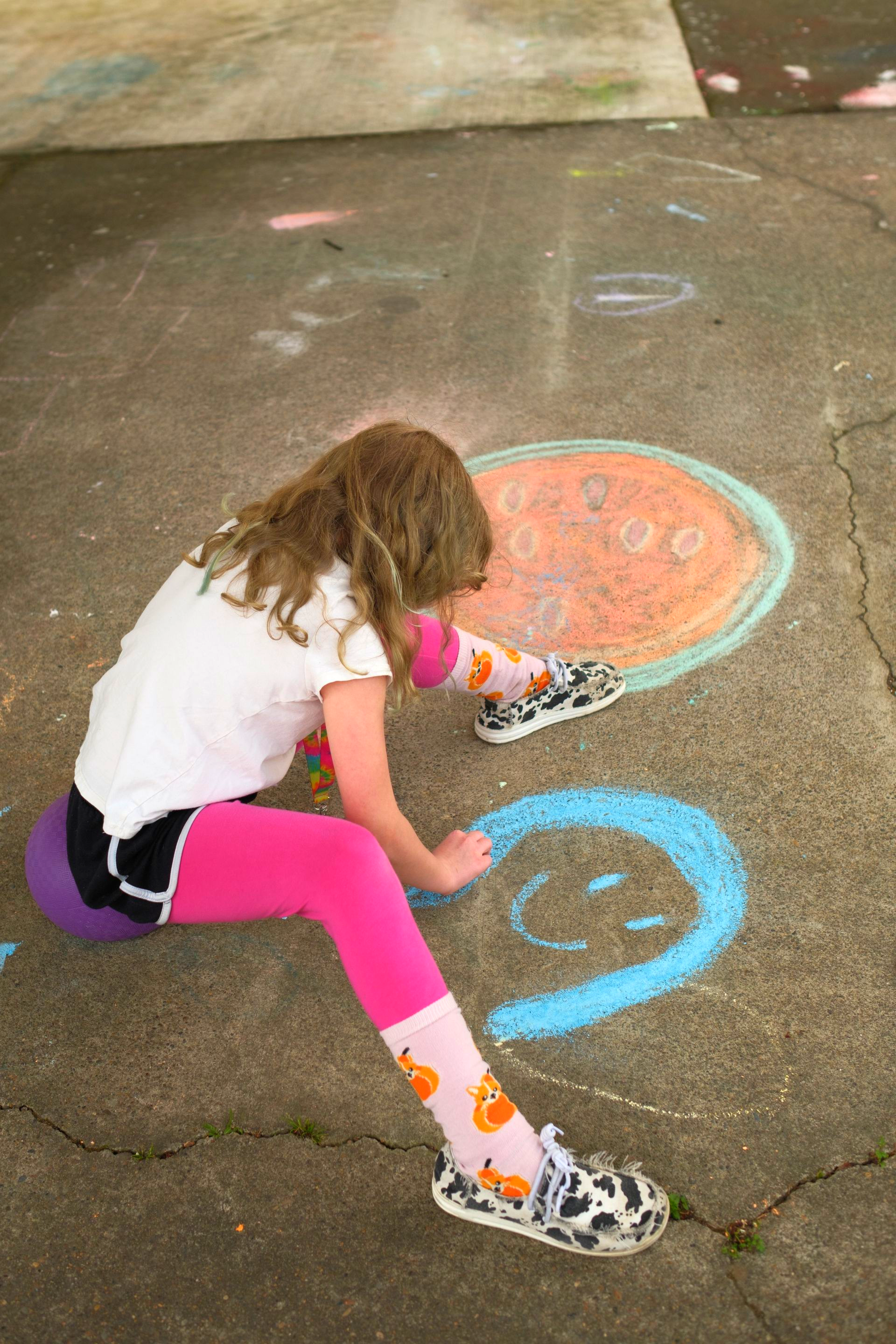 Group of people high-fiving outdoors in a grassy field. They are smiling, dressed in athletic wear.