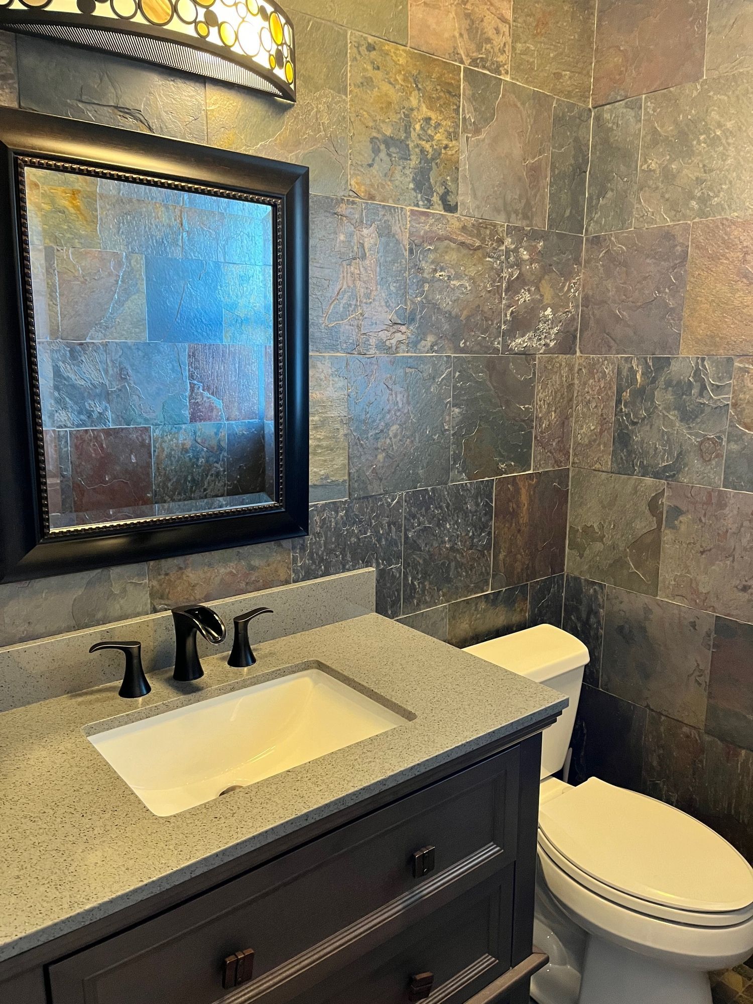 A bathroom with a sink , toilet and mirror.
