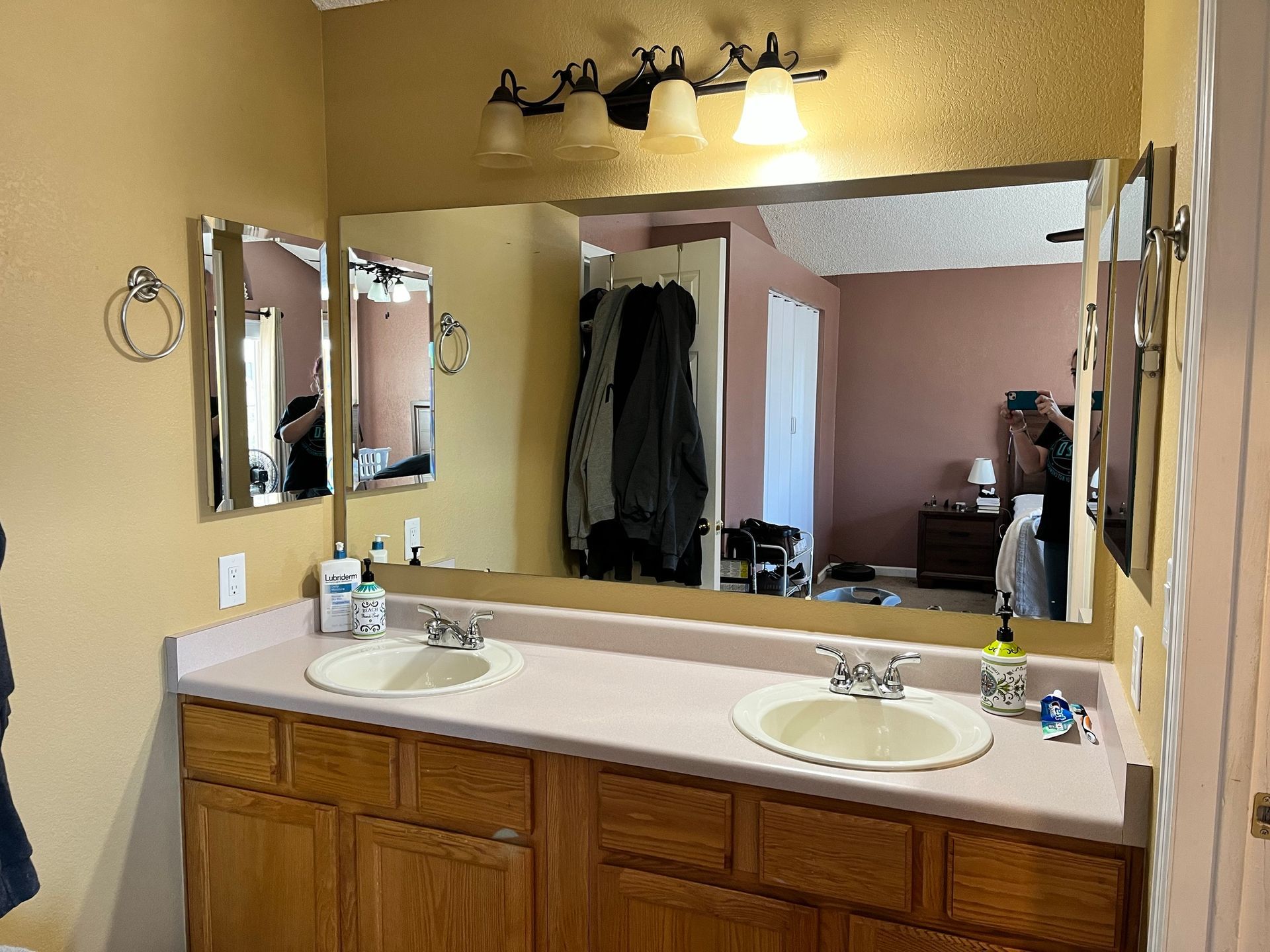 A bathroom with two sinks and a large mirror.
