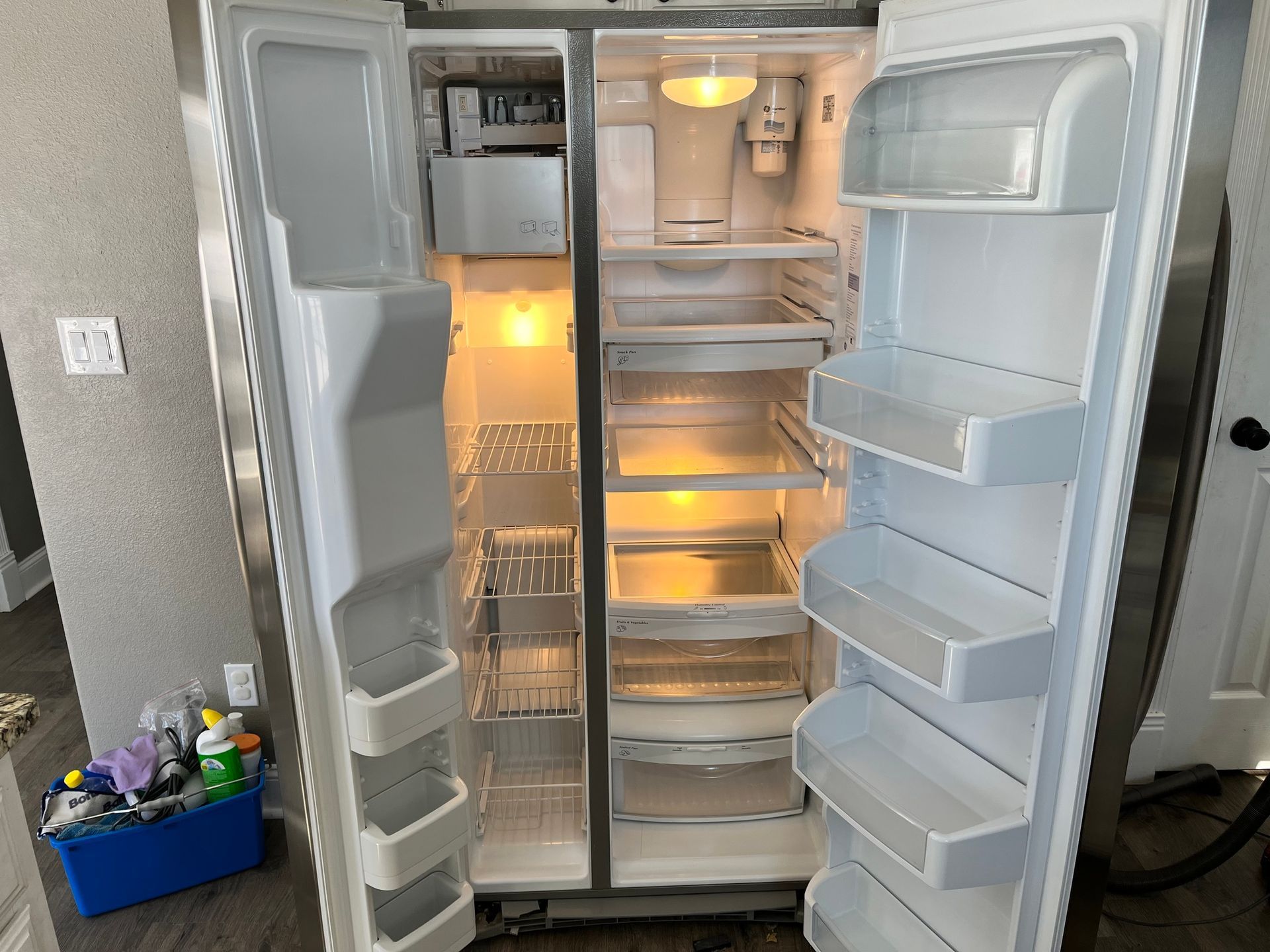 An empty refrigerator with the door open in a kitchen.