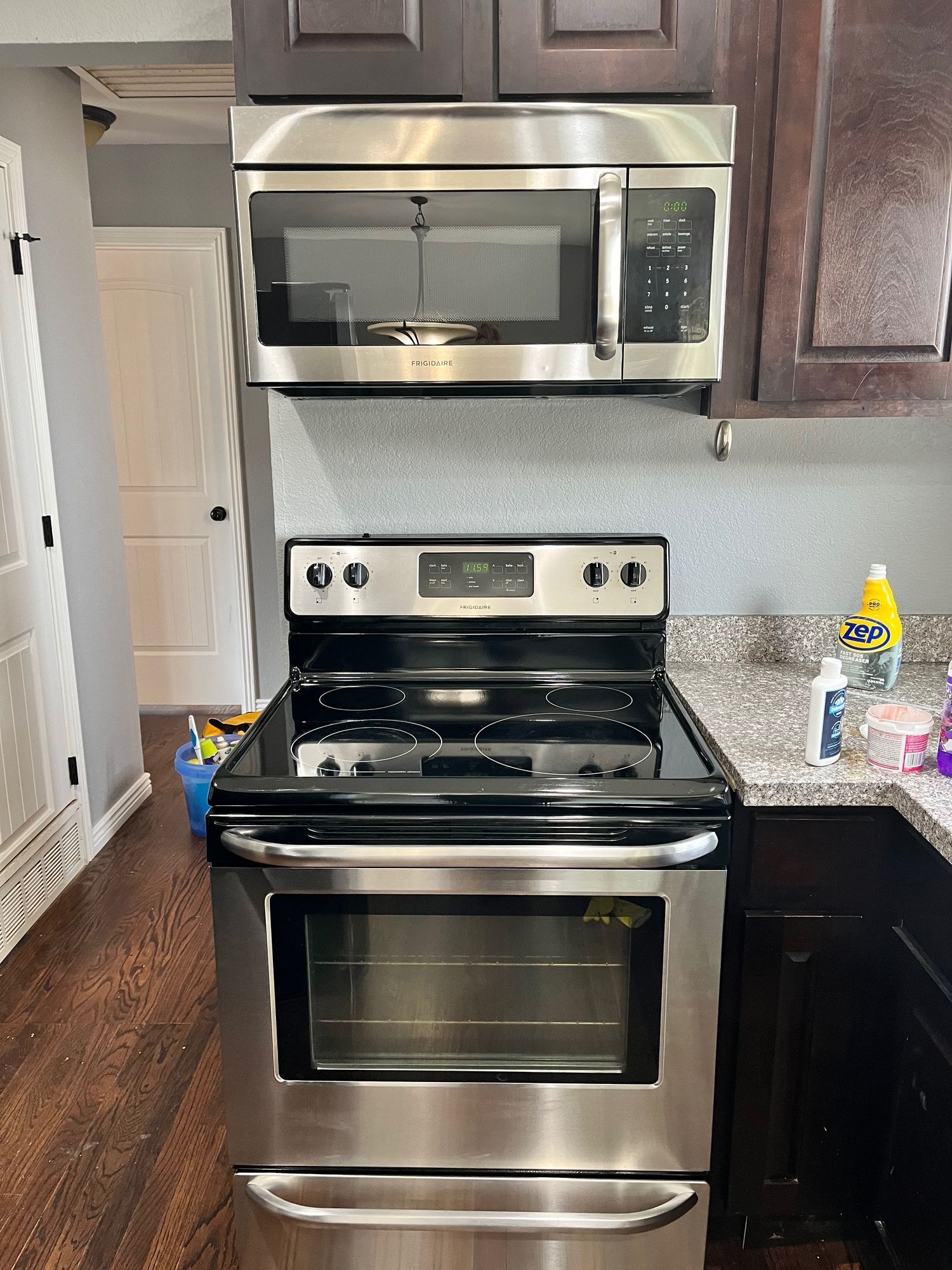 A stainless steel stove and microwave are in a kitchen.