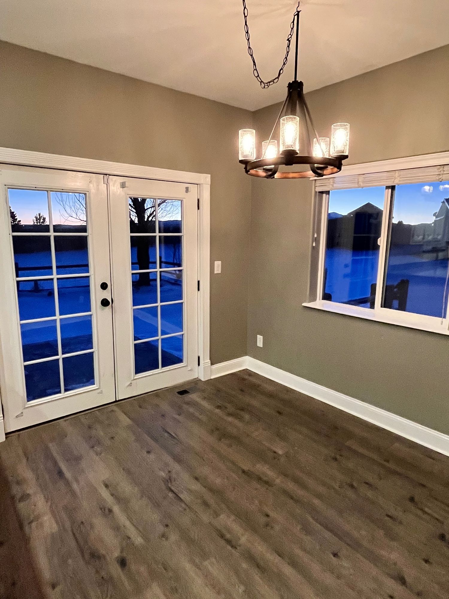 There is a chandelier hanging from the ceiling in the dining room.