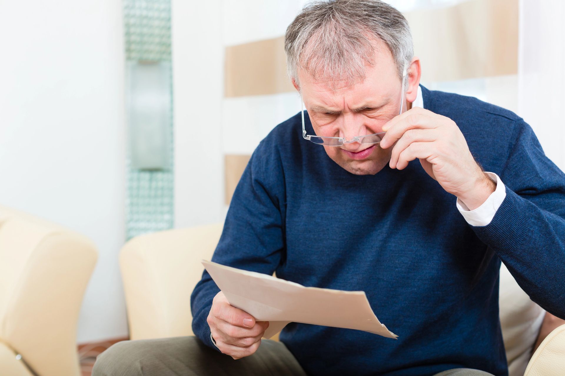 Middle aged man looking at a tax bill with a concerned expression