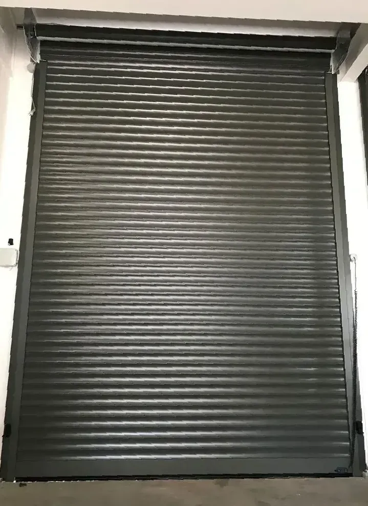 A White Garage Door Is Sitting In Front Of A Building — LT Shutters in Bellambi, NSW