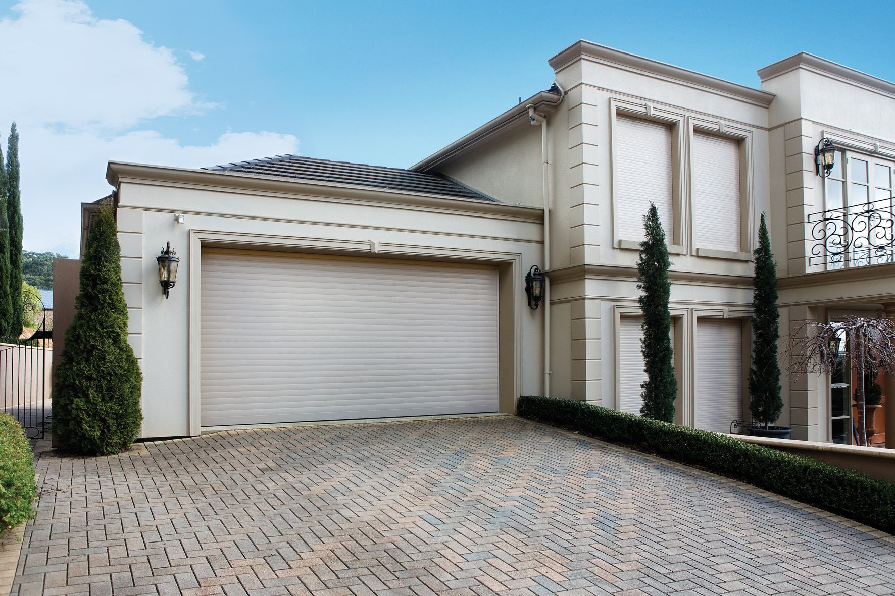 A White Garage Door Is Sitting In Front Of A Building — LT Shutters in Bellambi, NSW