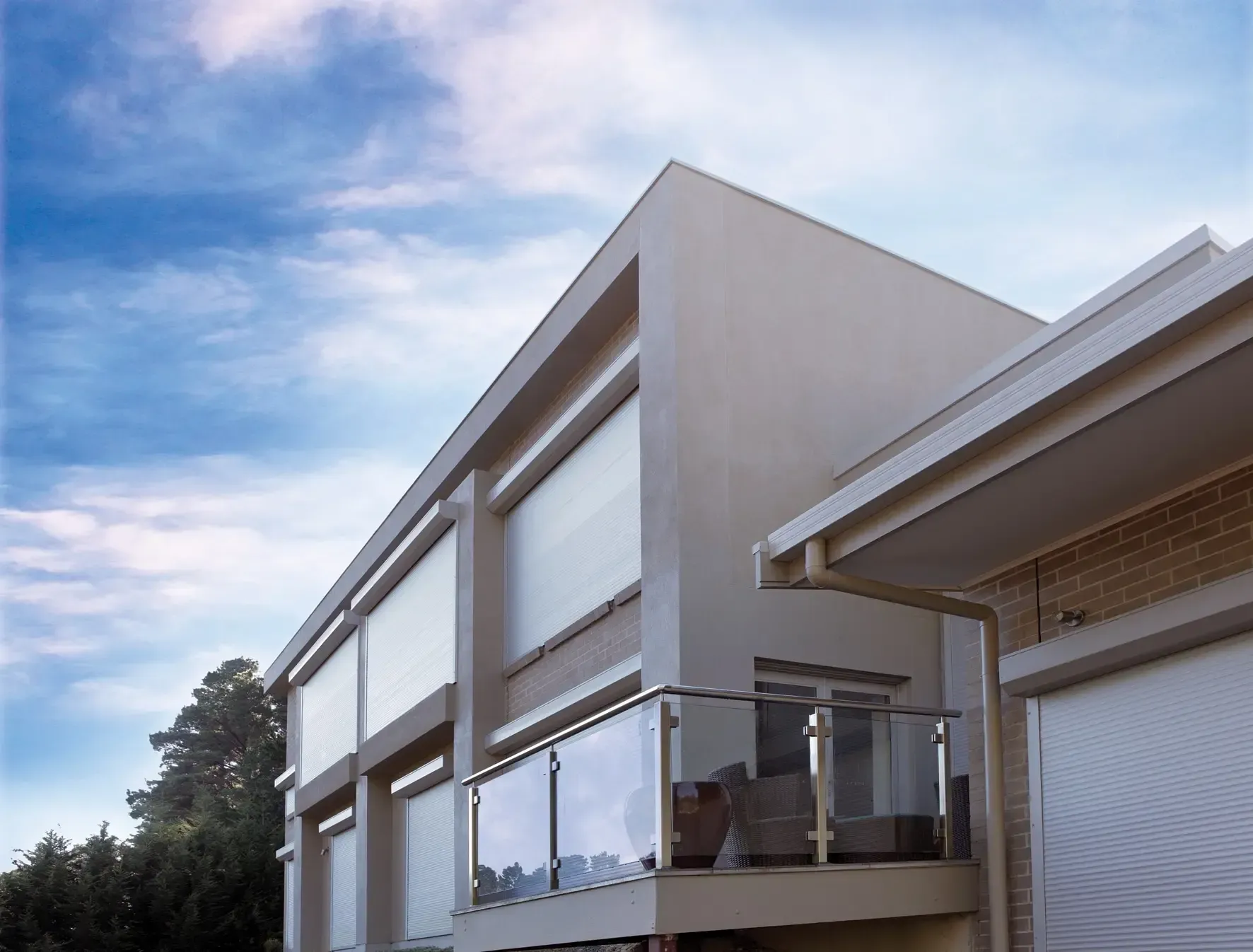 A house with a balcony and a blue sky in the background — LT Shutters in Thirroul, NSW