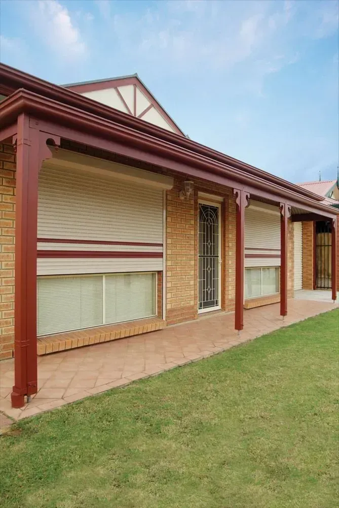 A brick house with a porch and shutters on the windows — LT Shutters in Thirroul, NSW
