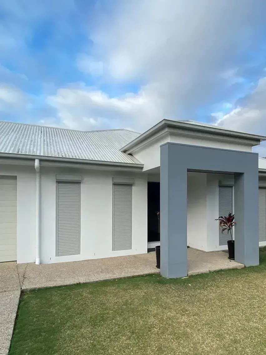 The Front Of A House With A Large Lawn In Front Of It — LT Shutters in Bellambi, NSW
