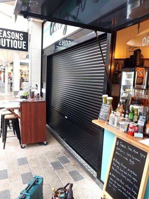 Black roller shutter installed on a café shopfront