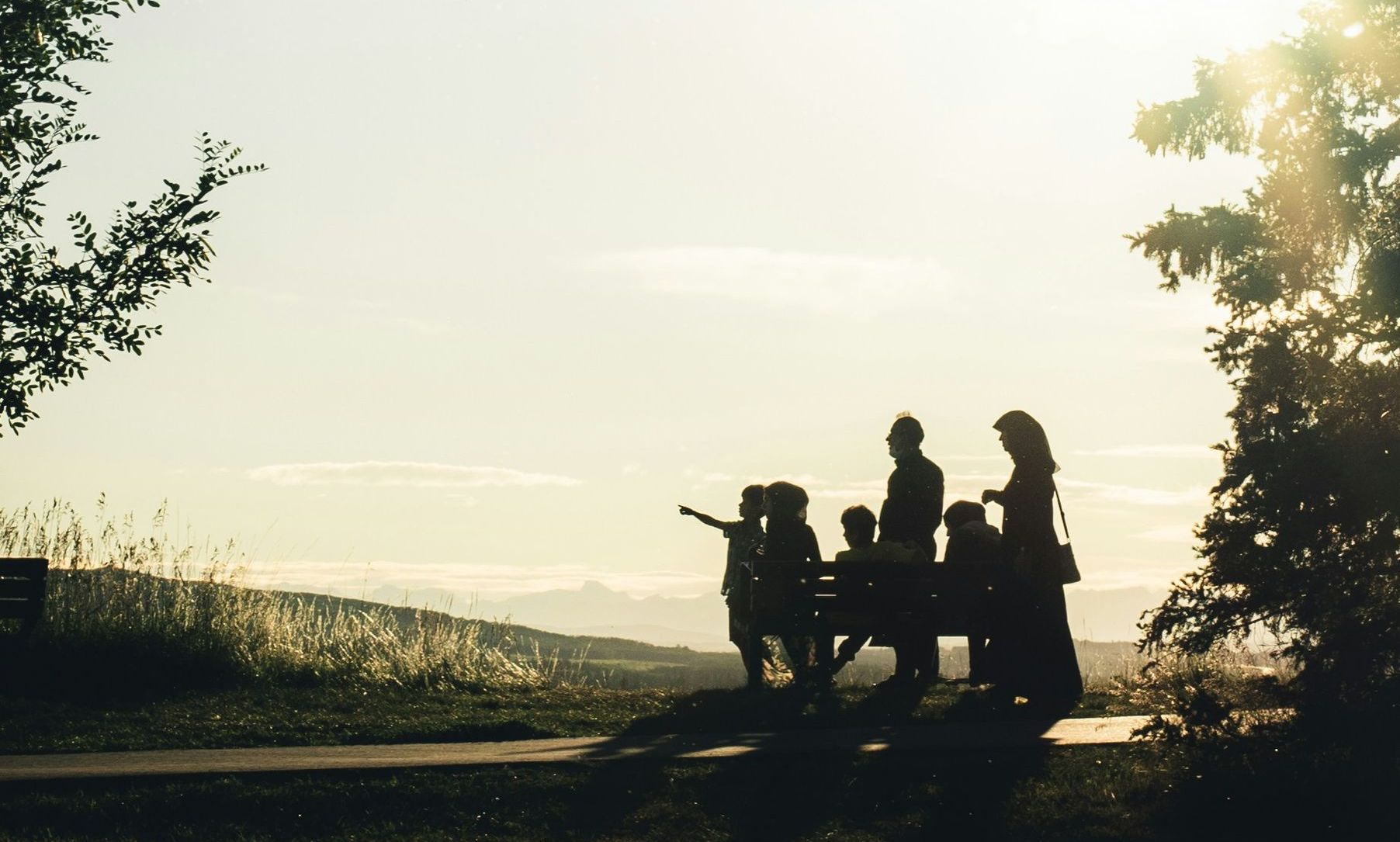 A silhouette of a family walking down a path.