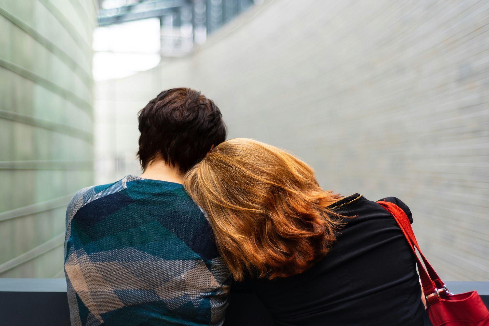 A man and a woman are sitting next to each other and hugging.