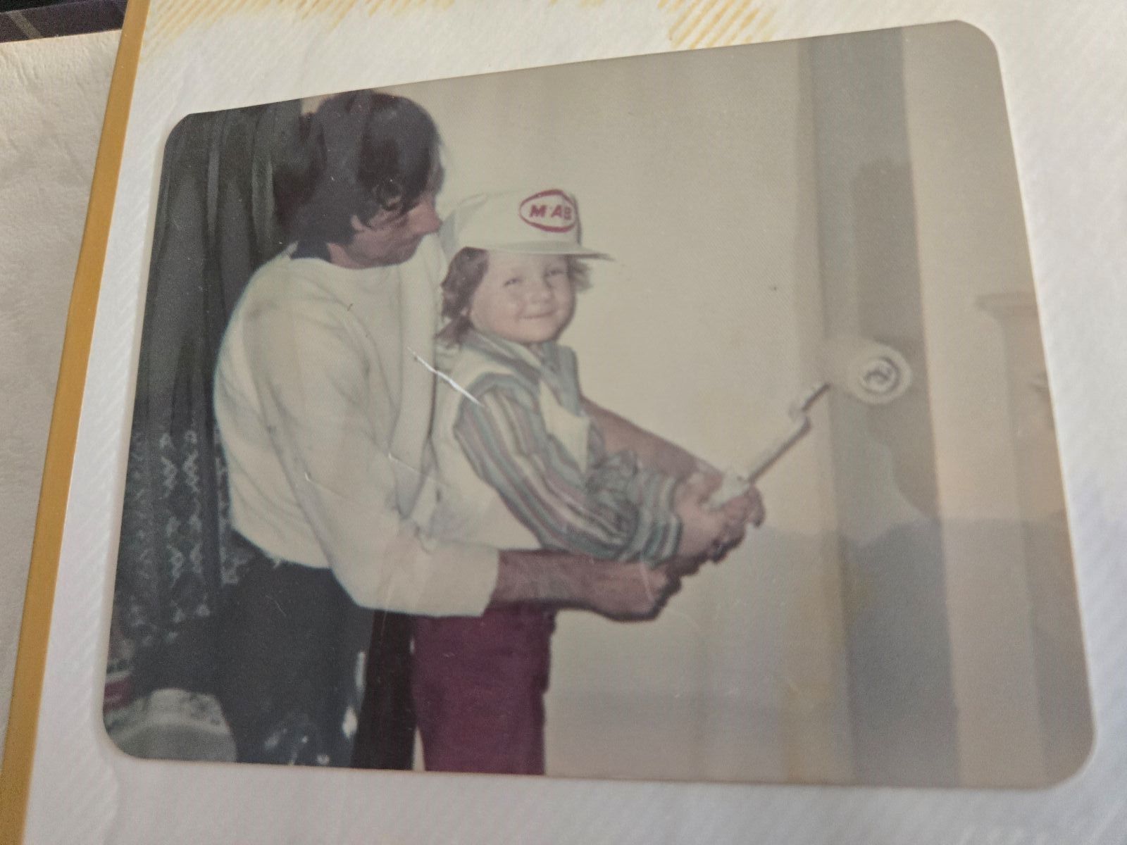Two men are painting a wooden floor in a barn.