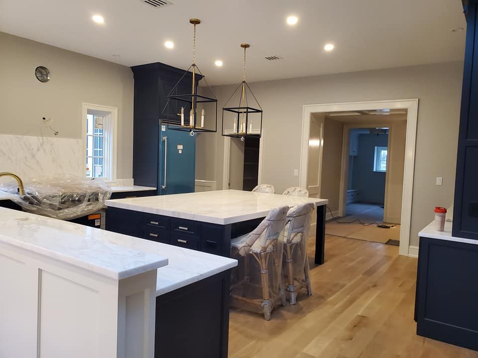 A kitchen with blue cabinets and white counter tops is being remodeled.