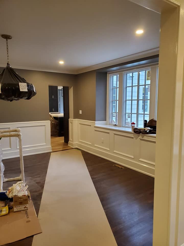 A living room with hardwood floors and a large window.