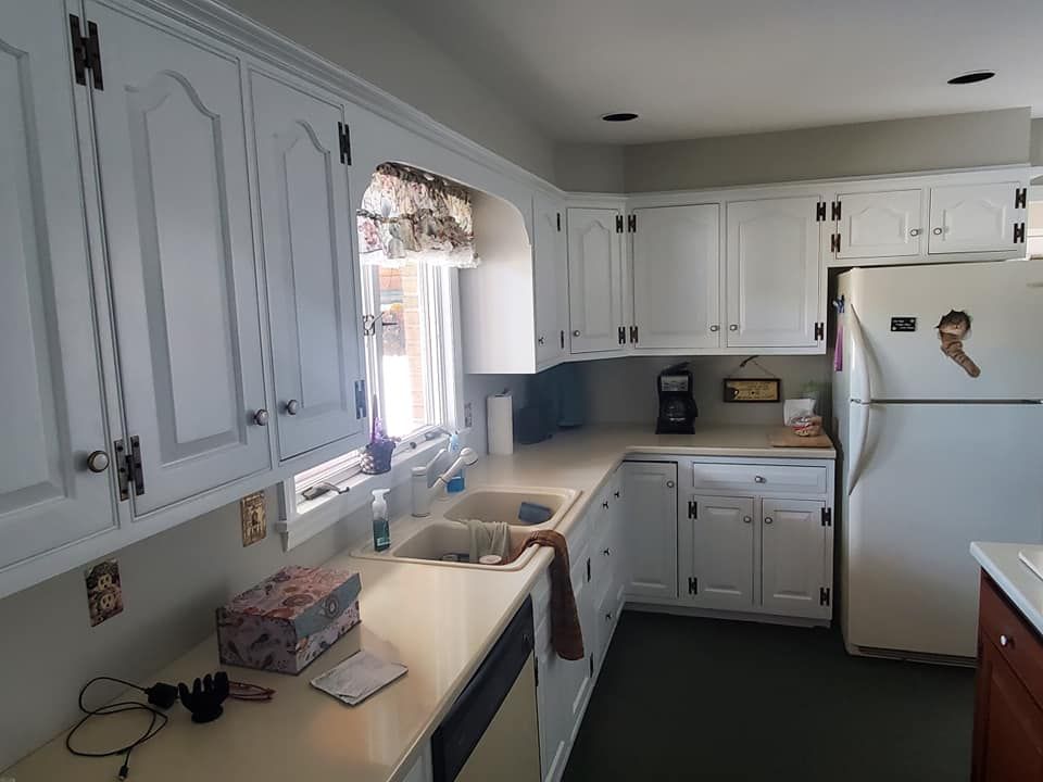 A kitchen with white cabinets and a white refrigerator