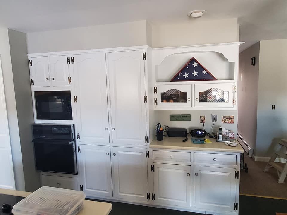 A kitchen with white cabinets and a flag on the shelf