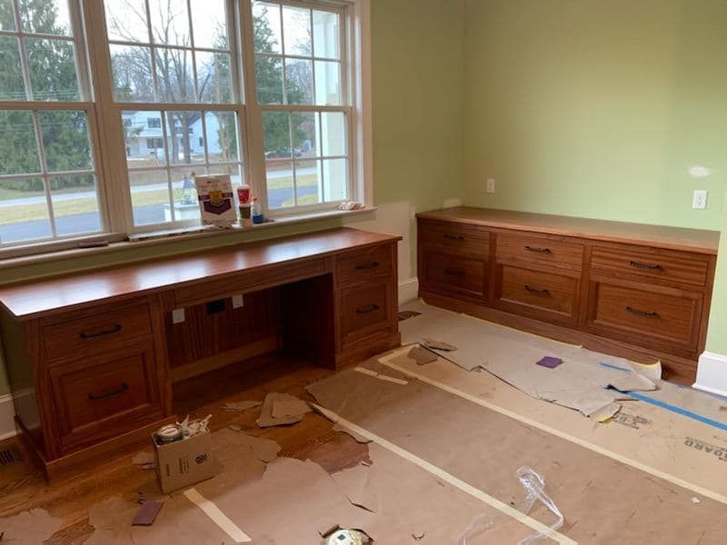 A room with a desk and drawers is being painted.