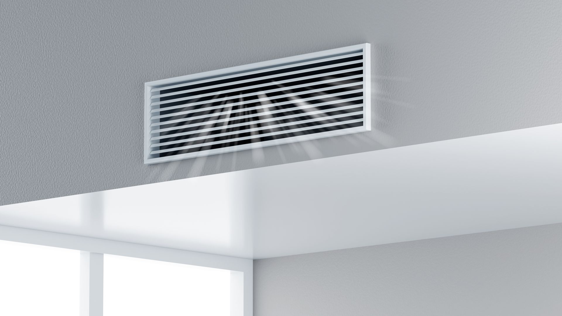Ceiling air vent above a white interior wall and window corner