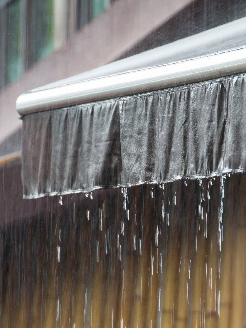 Rain falling from a dark awning, with water droplets visible.