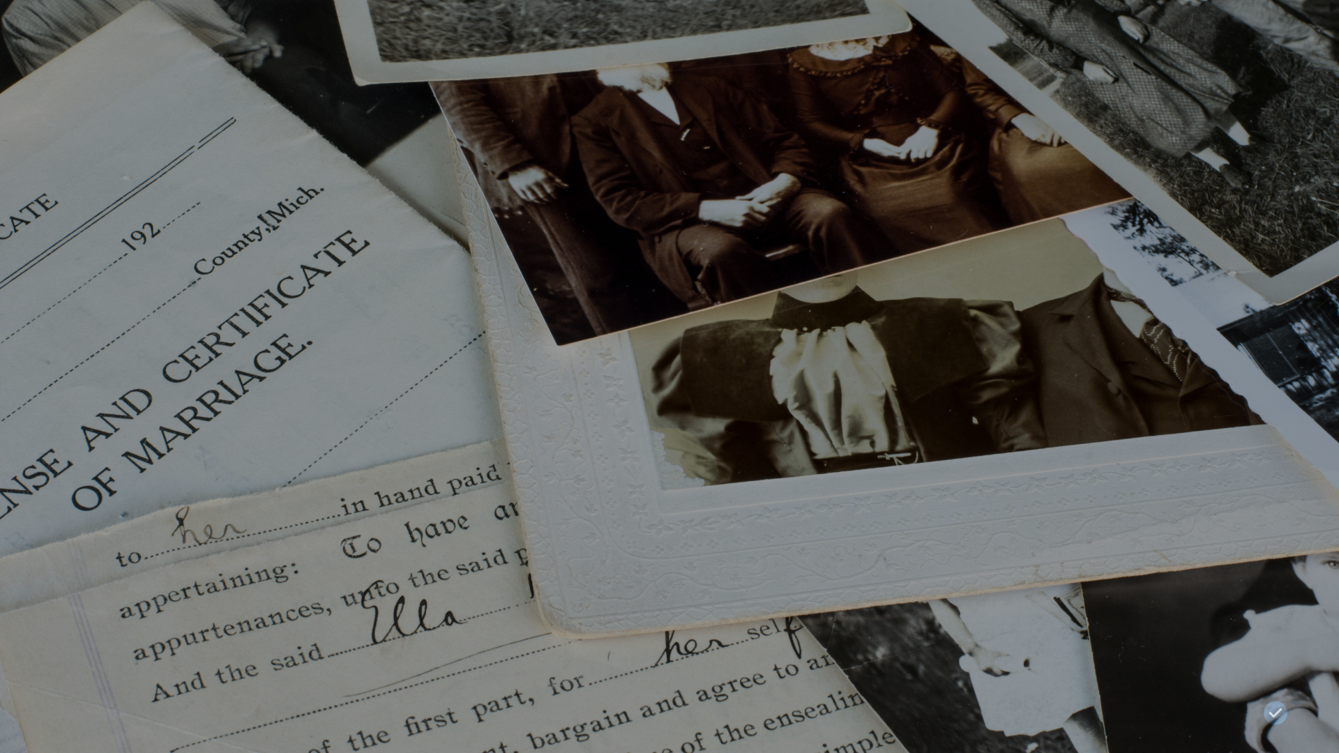 A close-up of old photographs and documents, including a marriage certificate and family pictures.