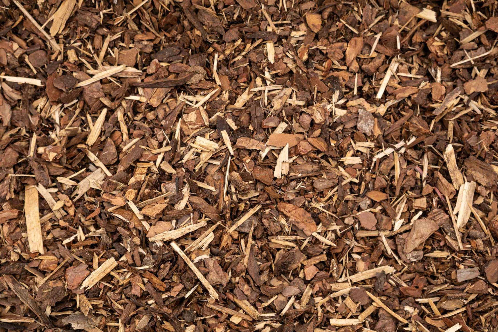 Brown wood chips and mulch scattered in a textured ground covering