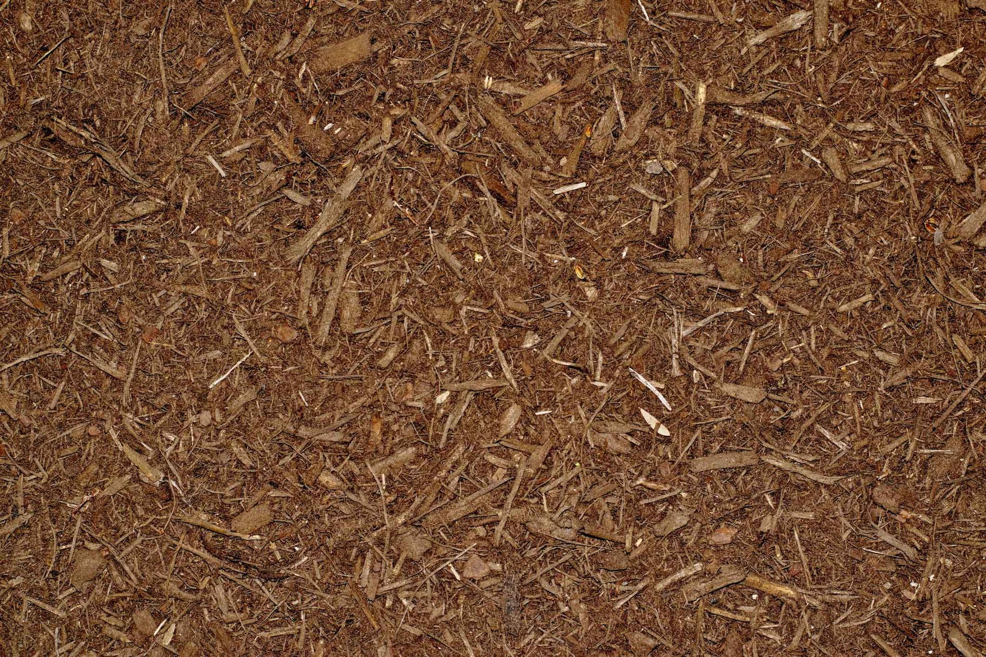 Brown wood mulch or bark chips filling the frame, with a rough, textured surface.