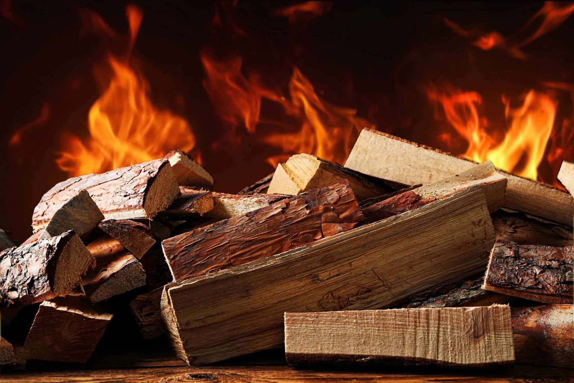 Stacked firewood burning in bright orange flames