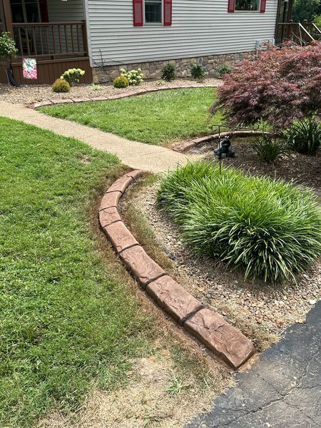 There is a brick curb in the middle of the yard.