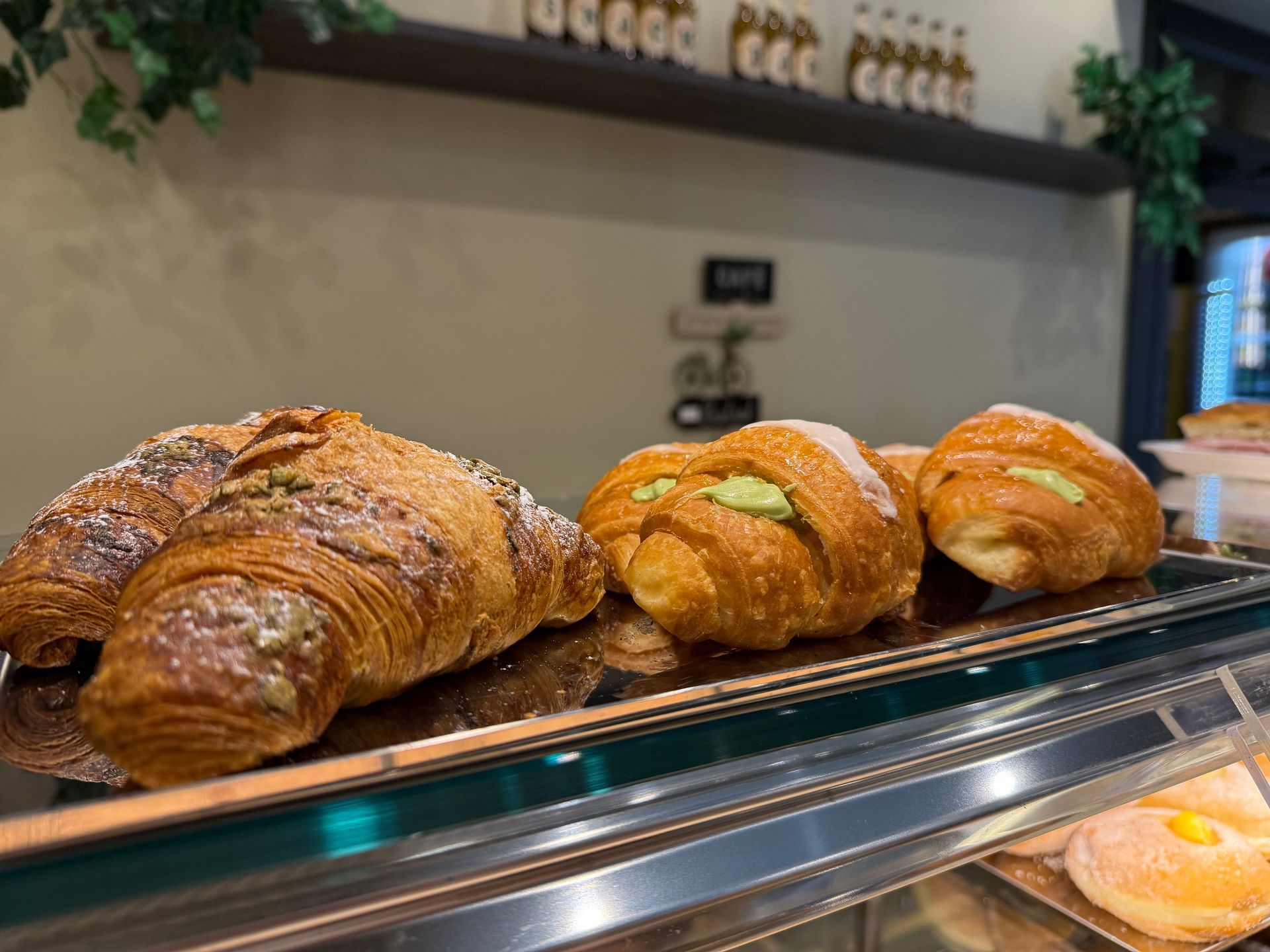 Vetrina con croissant, alcuni ripieni di crema, in un ambiente da panetteria.