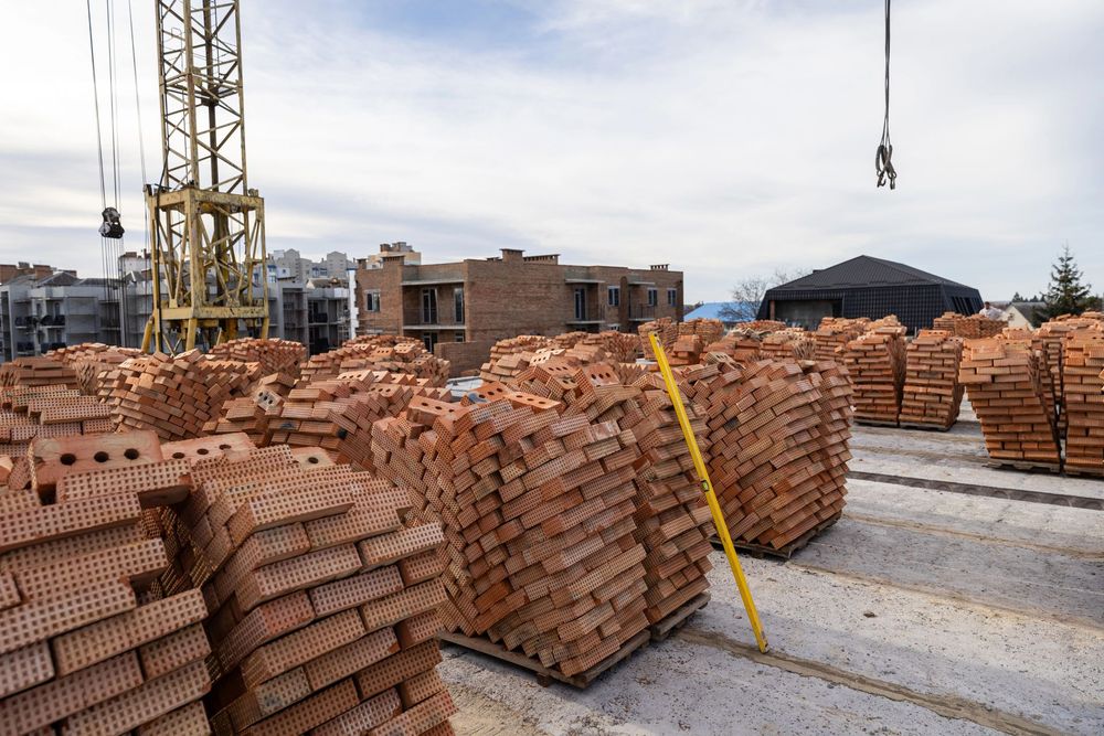 Escavatore al lavoro per uno scavo tecnico di fondazione con terreno rimosso e area di cantiere ordinata.