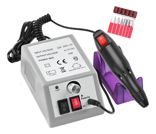 Taladro de uñas gris con pieza de mano negra sobre soporte morado, accesorios en la parte superior derecha.