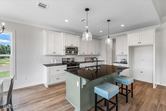 A kitchen with white cabinets and a large island in the middle.