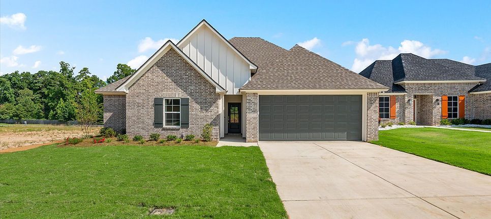 A large brick house with a large garage and a driveway.