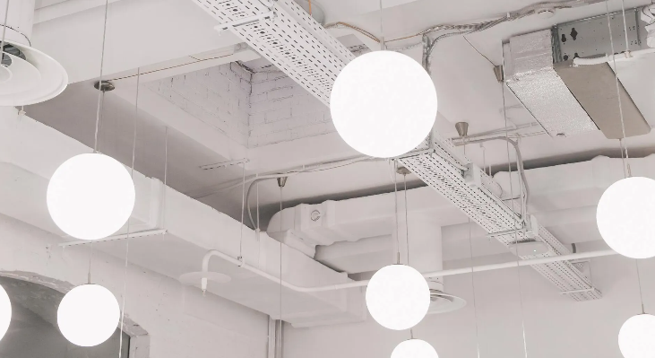 White globe pendant lights hanging from a white ceiling, in a minimalist setting.