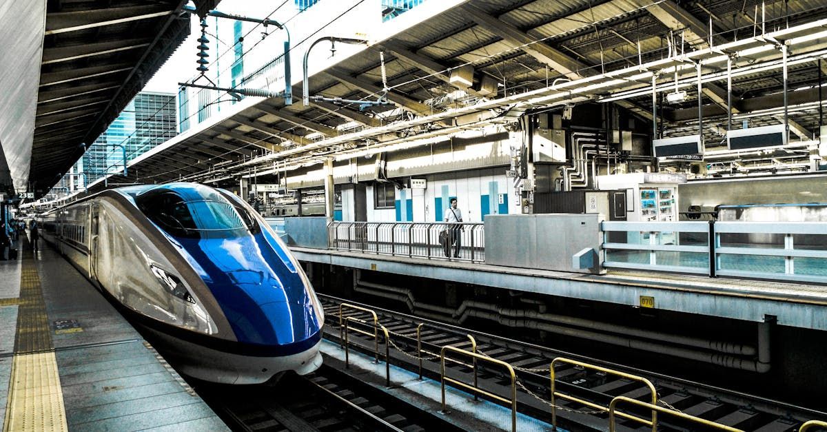 High-speed train in a station, blue and silver, ready to depart. Powered by Sky-Walker