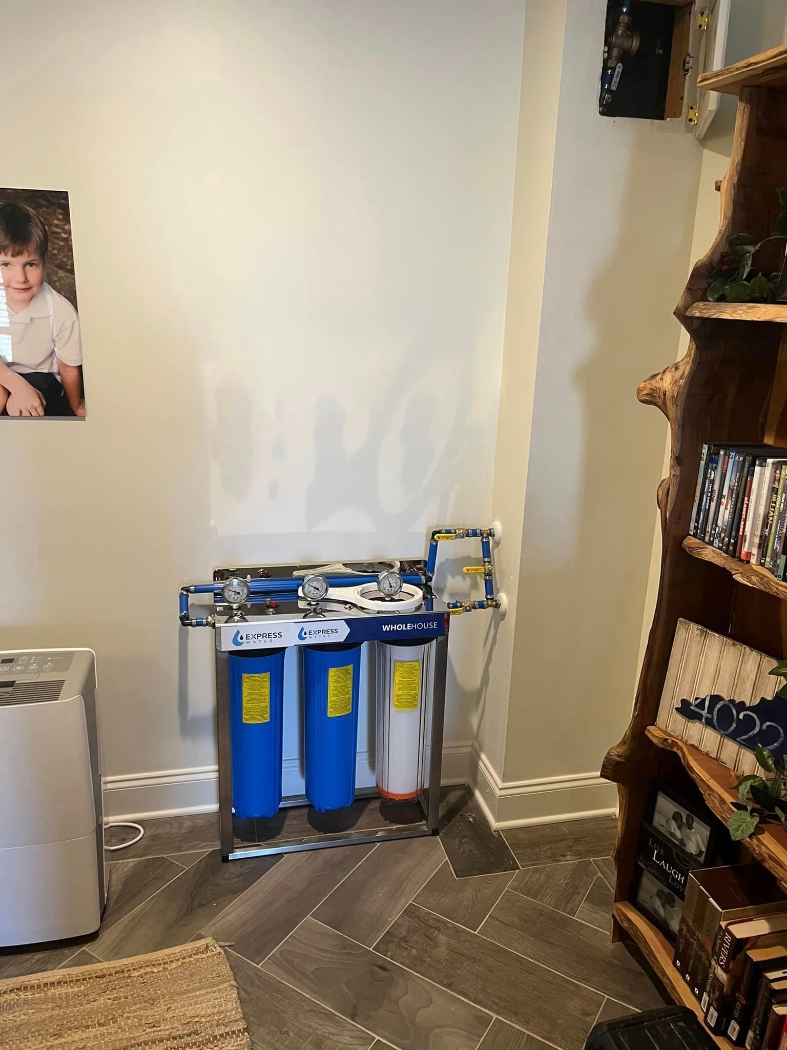 A room with a picture of a boy on the wall and a water filter.