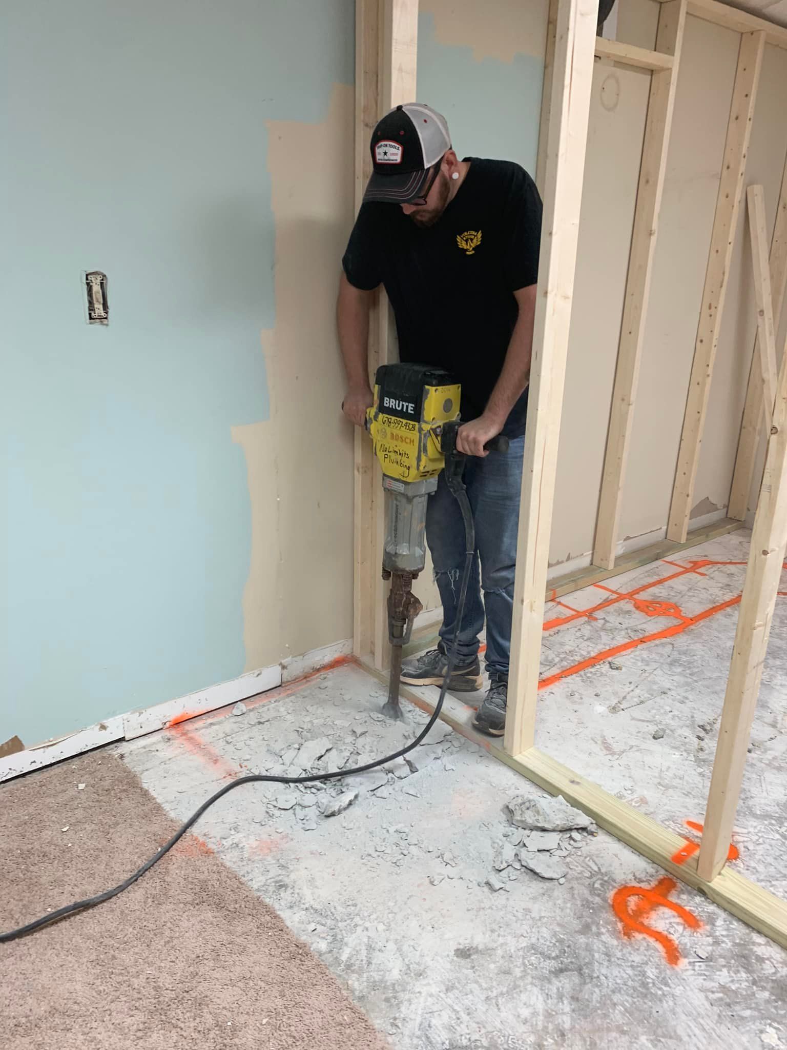 A man is using a hammer to drill a hole in the floor.