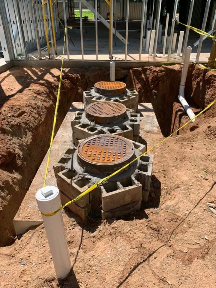 A group of manhole covers are sitting in a hole in the ground.