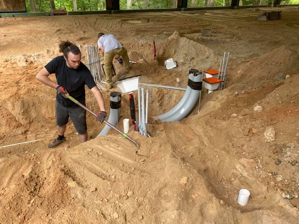 A man is digging in the dirt with a shovel
